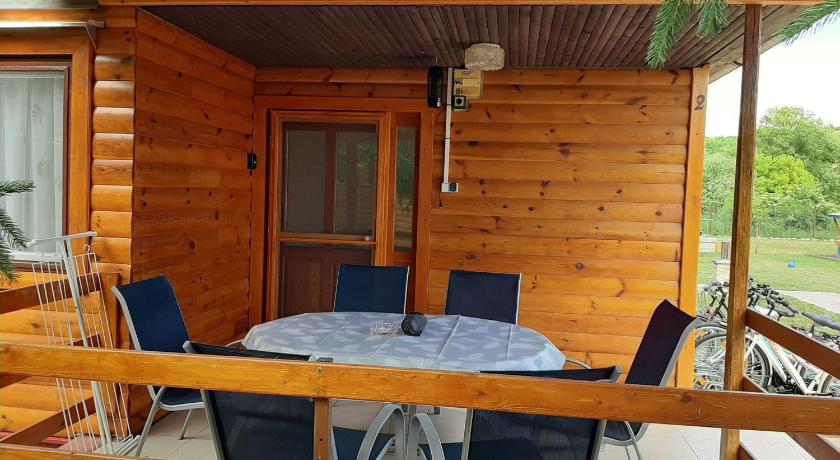 a dining room with a wooden table and chairs, Fortuna Apartmanhazak in Bogacs