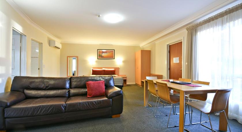 a living room filled with furniture and a table, Abel Tasman Motor Inn in Dubbo