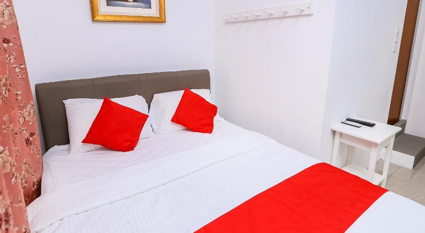a bed with white sheets and pillows in a room, OYO 89772 Roselyn Inn in Johor Bahru