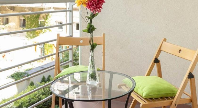 a table that has a vase with flowers on it, Corvin Plaza Apartments & Suites in Budapest