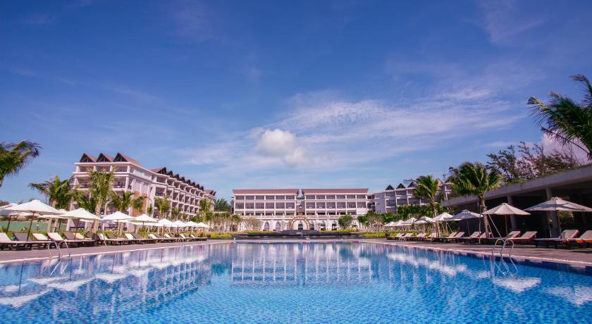 a large swimming pool in front of a large building, Muine Bay Resort in Phan Thiet