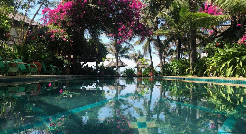 a pool with flowers in it, Full Moon Beach Resort in Phan Thiet