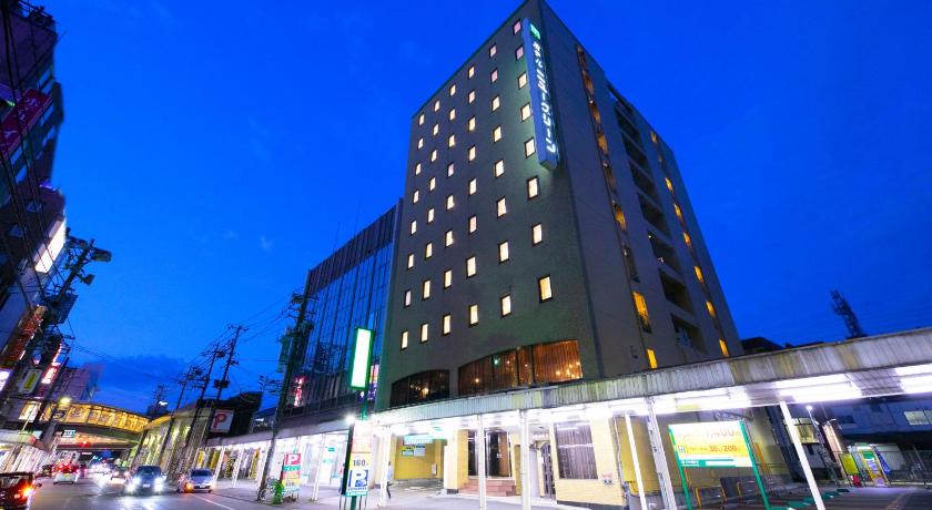 a large building with a clock on the side of it, Hotel New Green in Nagaoka