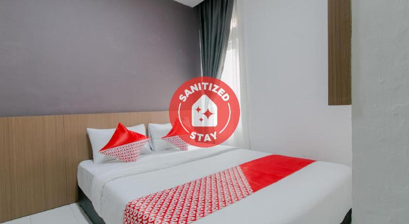 a hotel room with a bed and a clock on the wall, OYO 2228 Arwinda Costel Syariah in Puncak