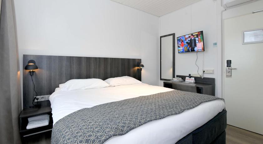 a hotel room with a bed and a desk, Het Wapen van Elst in Elst