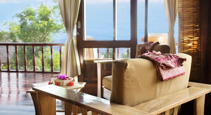 a living room filled with furniture and a table, Bunaken Oasis Dive Resort and Spa in Manado