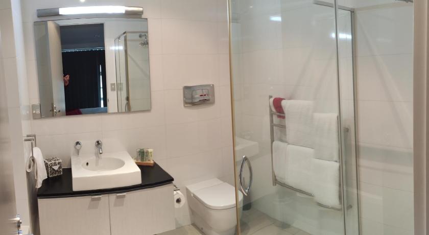 a bathroom with a toilet, sink, and shower, Doubtless Bay Villas in Mangonui