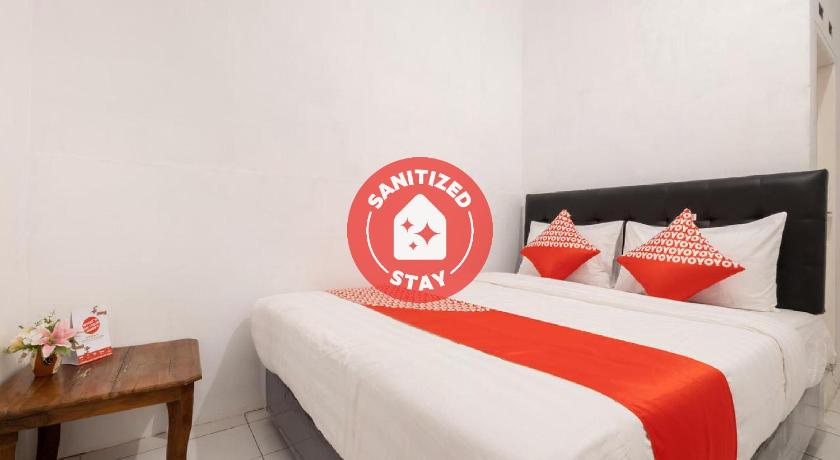 a hotel room with two beds with red pillows, OYO 2394 Hotel Brosta in Yogyakarta