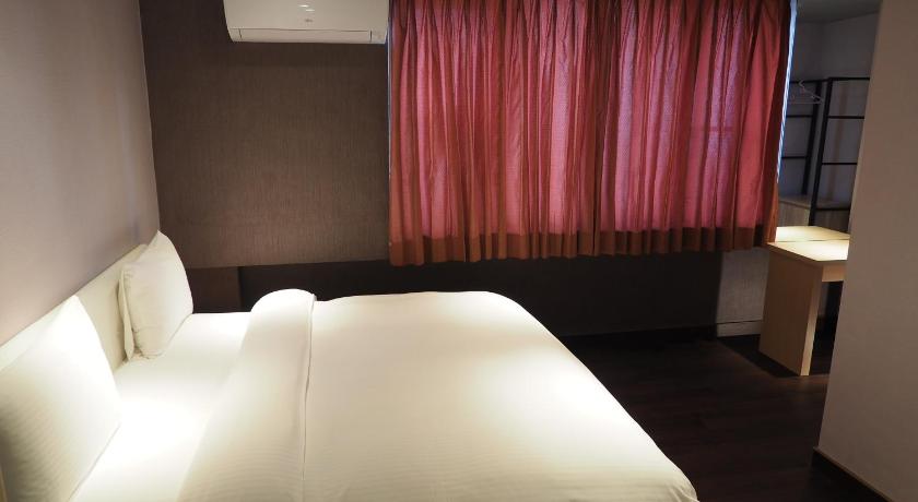 a bedroom with a white bed and white curtains, Day-Chen Hotel in Yilan