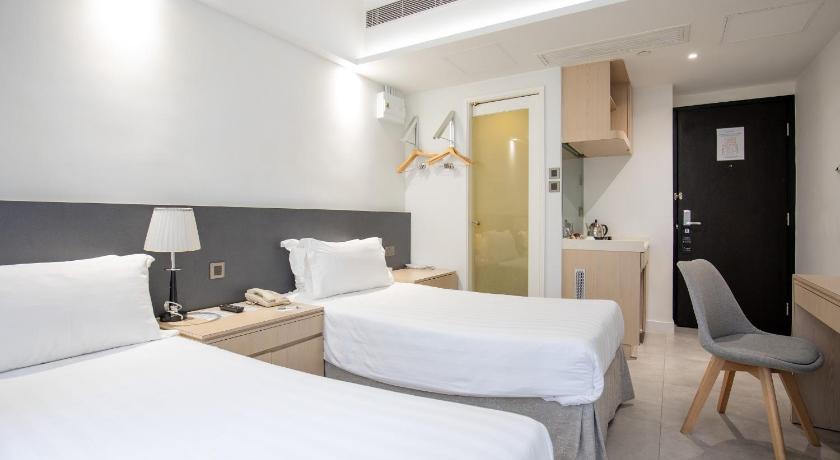 a hotel room with two beds and a television, Wifi Boutique Hotel in Hong Kong