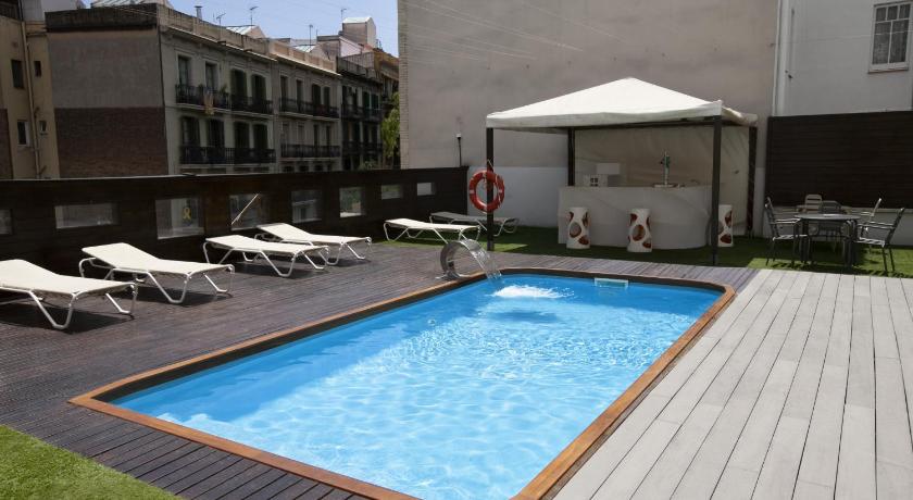 a pool with a pool table and chairs in it, Hotel Concordia Barcelona in Barcelona