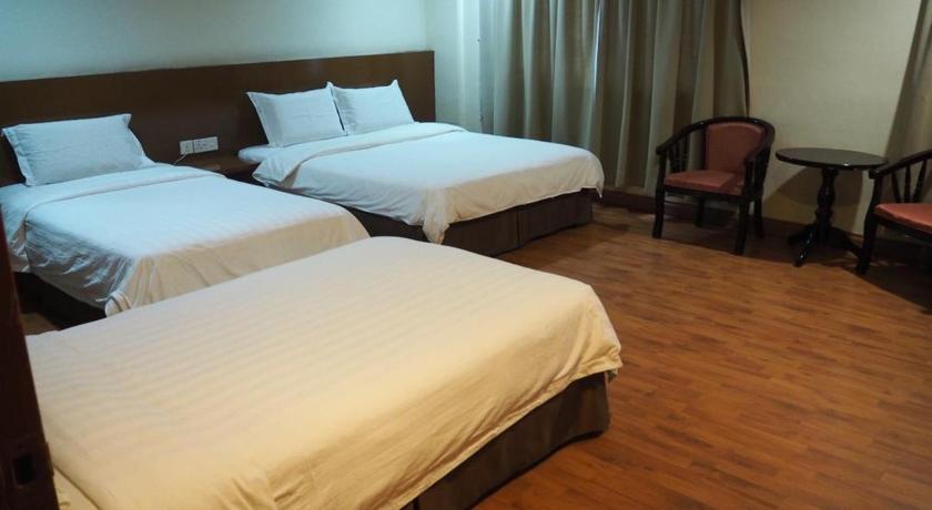 a hotel room with two beds and two nightstands, 906 Hotel Melaka Raya in Malacca