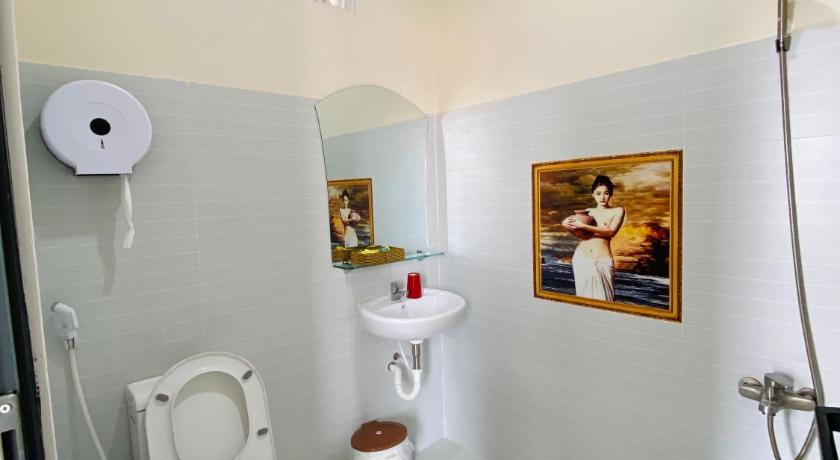 a bathroom with a toilet, sink, and mirror, T-HOUSE Homestay Mui Ne in Phan Thiet