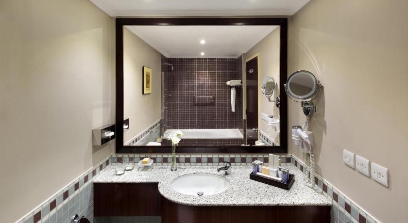 a bathroom with a sink, toilet and mirror, Anwar Al Madinah Movenpick Hotel in Medina