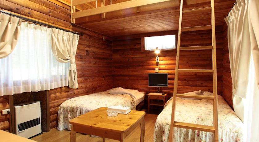 a bedroom with a bed and a chair in it, Cottage Inn Log-cabin in Karuizawa