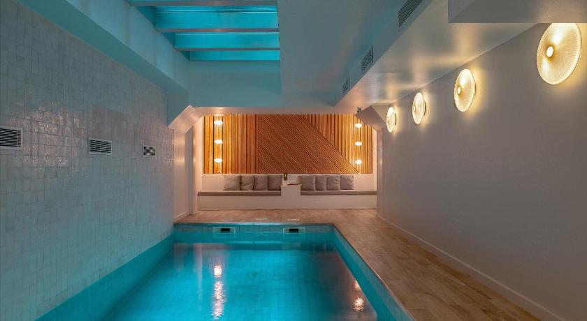a bath room with a tub and a pool, Lyric Hotel Paris Opera in Paris