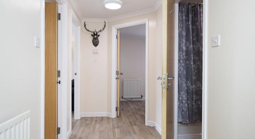 an empty room with a white floor and wooden floors, Lochend Serviced Apartments in Edinburgh