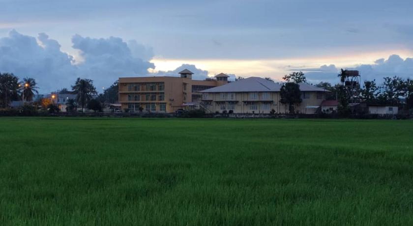 a grassy field with a building in the distance, Soo Guan Villa in Arau