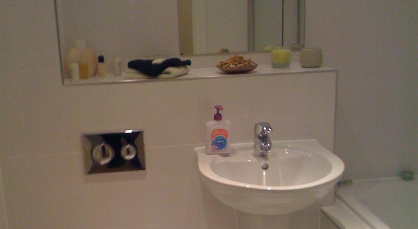 a white sink sitting under a mirror in a bathroom, Apple House Guesthouse Heathrow Airport in London