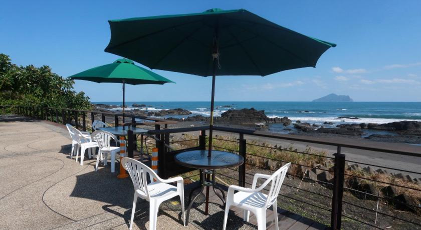 a patio area with chairs, tables and umbrellas, Jia Ying Beach Resort B&B in Yilan