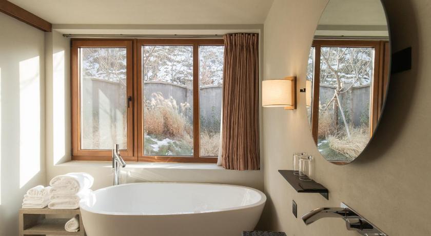 a bath room with a tub and a window, Sansavillage in Beijing