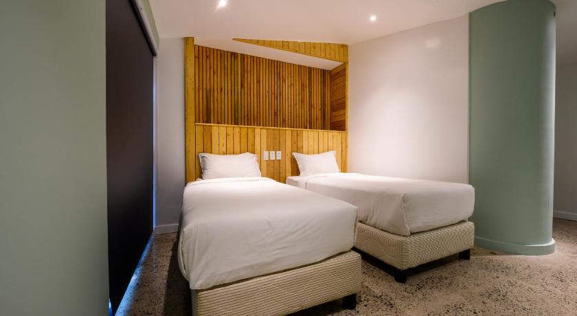 a bedroom with a bed and a dresser, G1 Lodge Design Hotel in Baguio