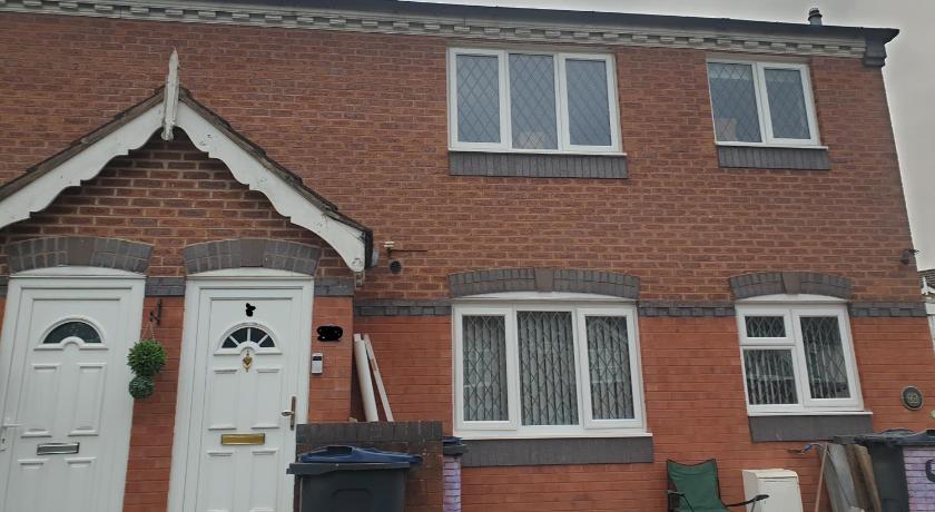 a white and black fire hydrant in front of a brick building, Four Bedroom House Close to the City Hosted Be More Homely Serviced Accommodation & Apartments Birmi in Birmingham