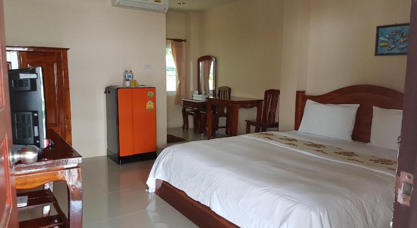 a bedroom with a bed, chair, and table in it, RACHAPHRUKRESORTLOPBURI in Lopburi