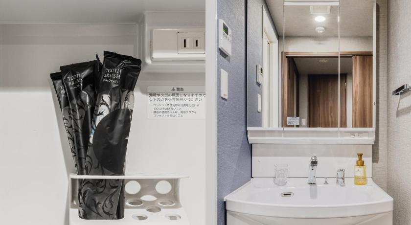 a bathroom with a sink, mirror, and toilet, Bon Condominium Namba Ebisu in Osaka