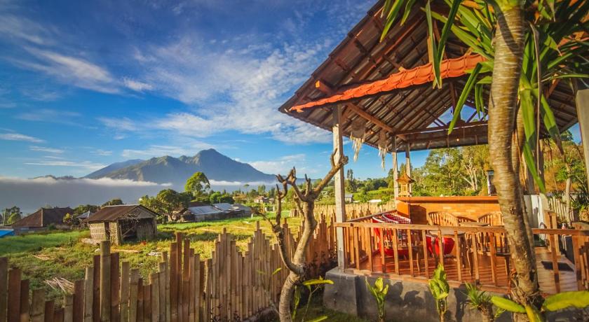 a wooden bench sitting in front of a lush green field, Batur Homestay in Bali