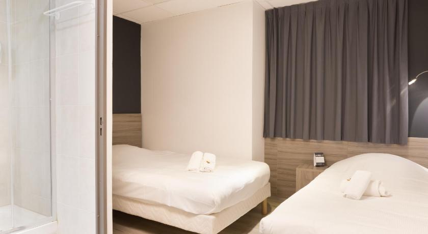 a bedroom with a white bed and white walls, Lille City Hotel in Lille
