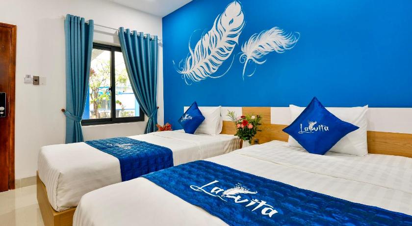 a hotel room with two beds and two windows, La Vita Hotel in Vung Tau