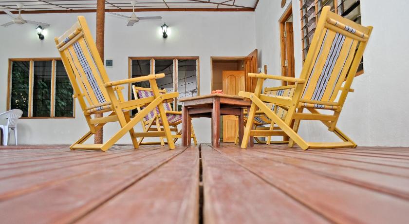 a wooden bench sitting next to a wooden table, Fulidhoo La Perla Guest House in Maldive Islands