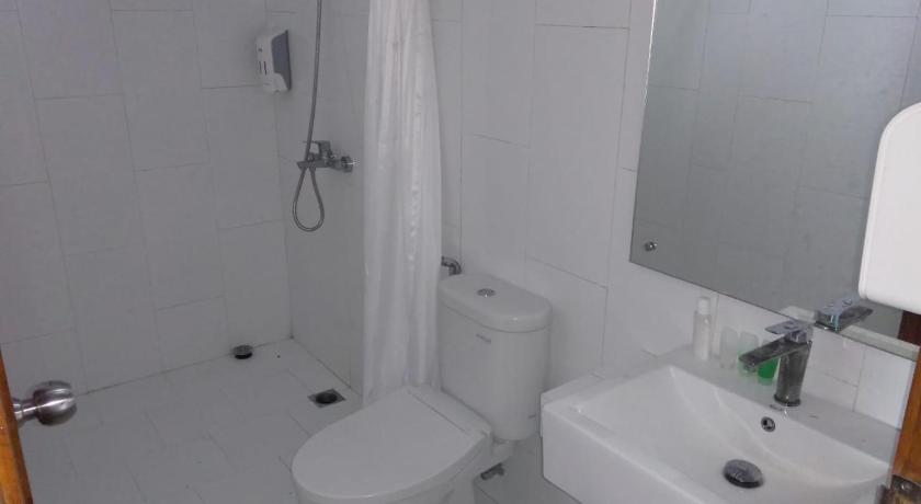 a white toilet sitting next to a sink in a bathroom, Radika Paradise Villa & Cottage in Bedoyo