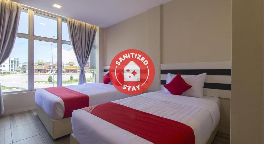 a hotel room with a large bed and a large window, OYO 1145 Lea Guest House & Cafe in Port Dickson