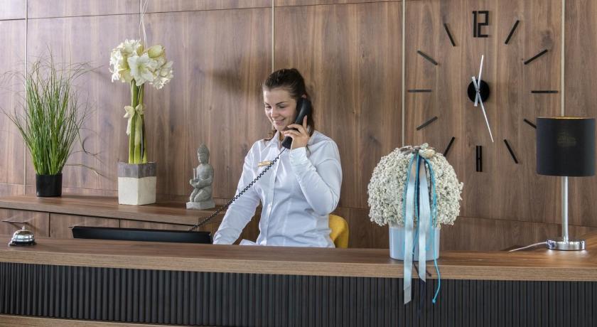 a woman standing in front of a counter with a vase on it, Balneo Hotel Zsori Thermal & Wellness in Mezokovesd