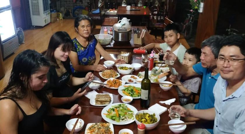 people sitting at a table with plates of food, Tam Coc Melody Homestay in Ninh Bình
