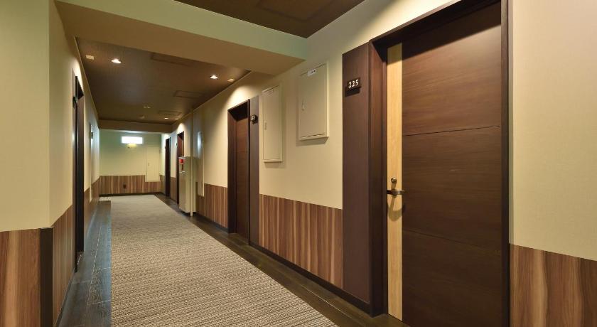 a hallway with a door leading into a room, Yumoto Shirogane Onsen Hotel in Furano