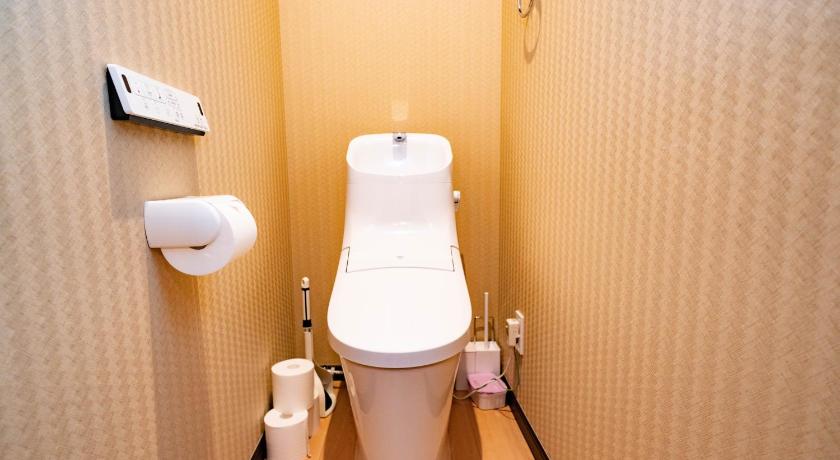 a white toilet sitting in a bathroom next to a wall, EAST ONE Higashishinjuku in Tokyo
