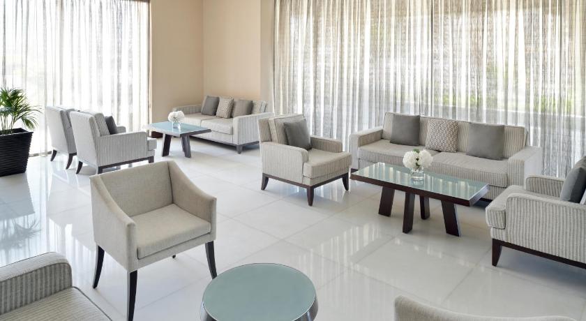 a living room filled with furniture and a large window, Movenpick Hotel Apartments Al Mamzar Dubai in Dubai