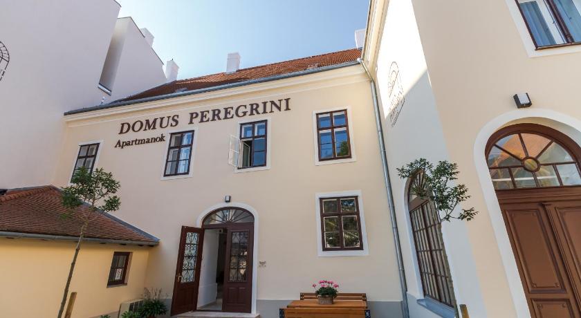 a large brick building with a clock on the front of it, Domus Peregrini Apartmanok in Gyor