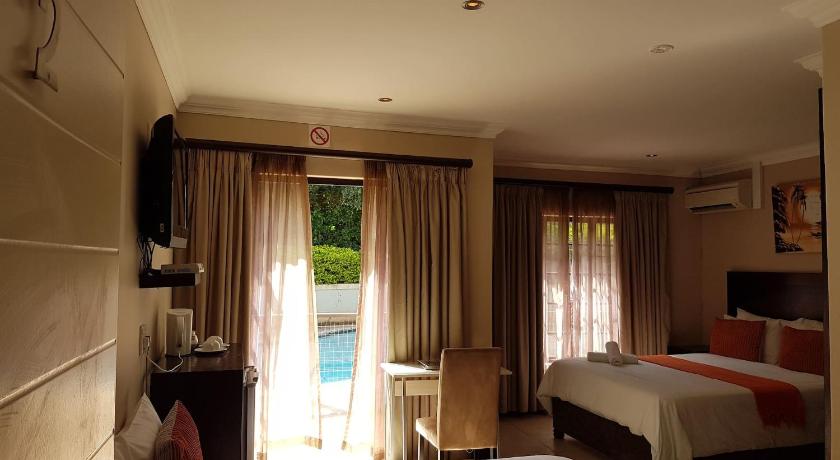 a hotel room with two beds and a television, Fairview Bed and Breakfast in Durban