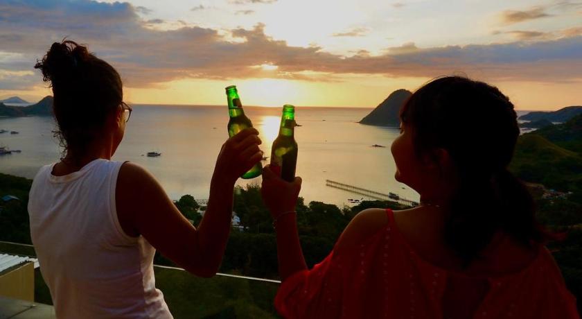 two women standing next to each other on a beach, Sunset Hill Hotel in Labuan Bajo