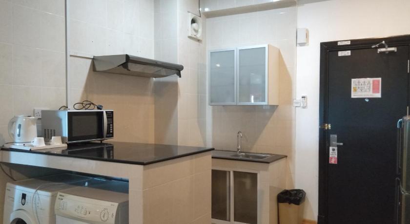 a kitchen with a microwave and a refrigerator, Hotel Gina Suite in Bandar Seri Begawan