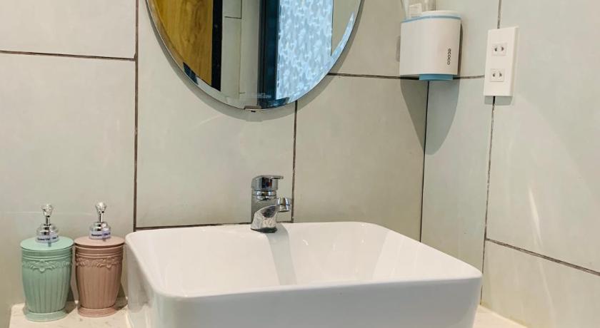 a white sink sitting under a mirror in a bathroom, Aurora Beach House in Phu Quoc Island