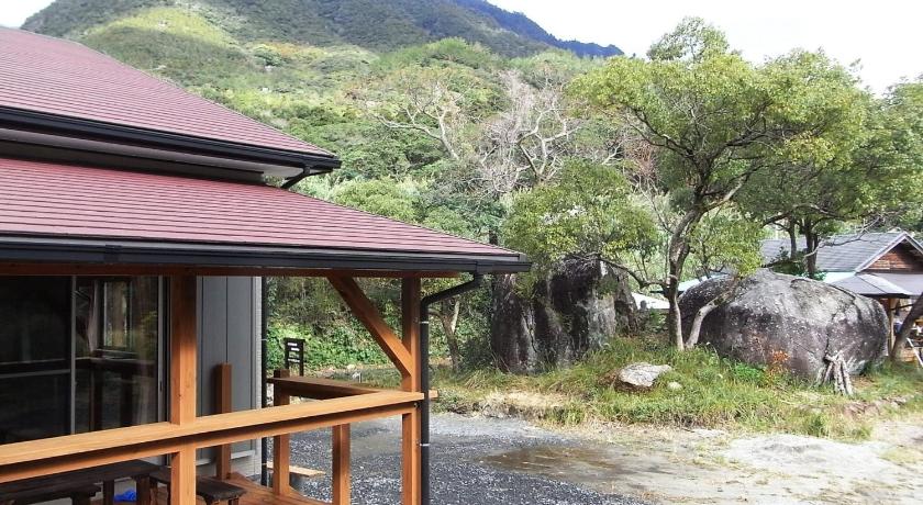 a house with a wooden roof and trees, Guesthouse Yakushima in Yakushima