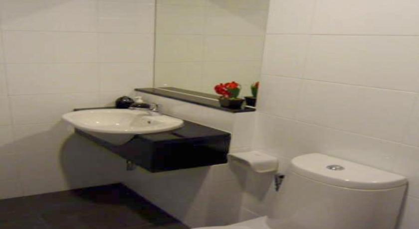 a bathroom with a sink, toilet and mirror, The Atrium Ratchada 13 Hotel in Bangkok