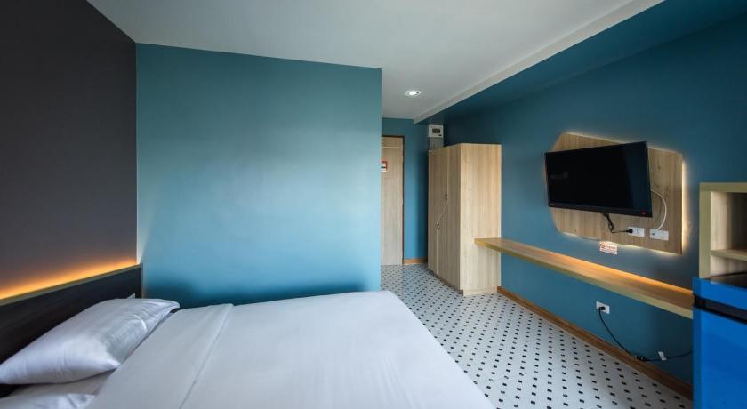 a hotel room with a bed and a television, The Feeling Hotel in Rayong