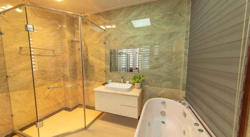 a bathroom with a tub, toilet and shower stall, Villa FLC BT 10 - 04 in Hạ Long