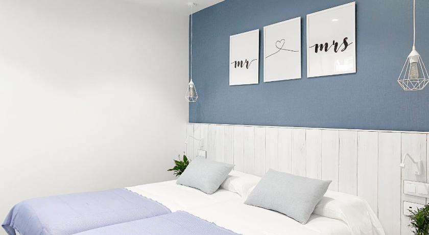 a hotel room with a white bed and white walls, Nerja Casual Rooms in Nerja